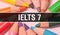 IELTSÂ 7 concept banner with texture from colorful items of education, science objects and 1 september School supplies. IELTSÂ 7